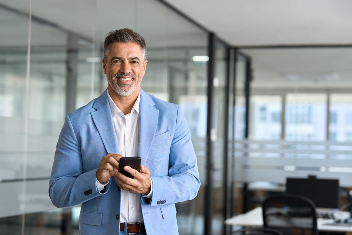 Senior supply chain leader in a blue blazer holding a phone