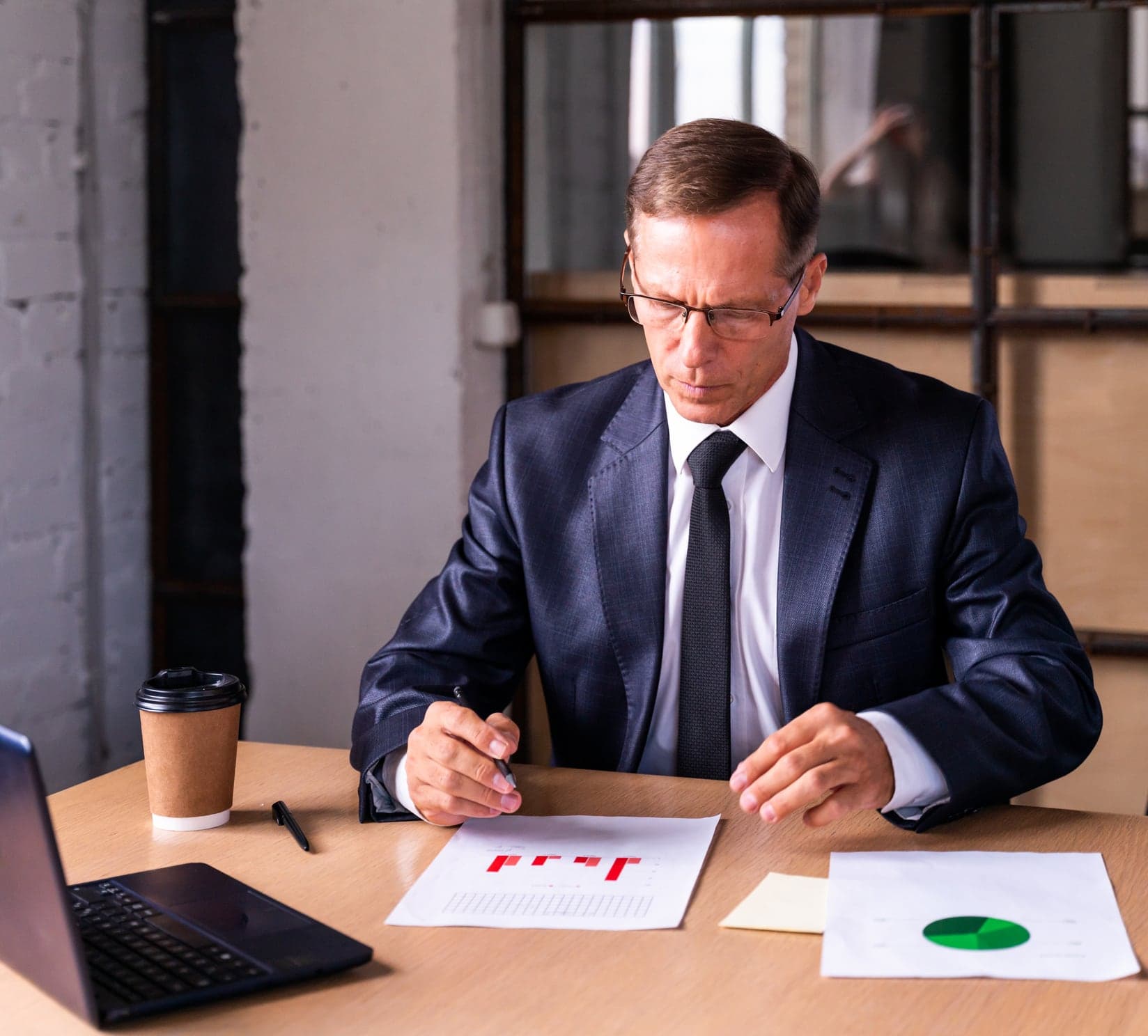 A manager reviewing a printed performance report at a desk