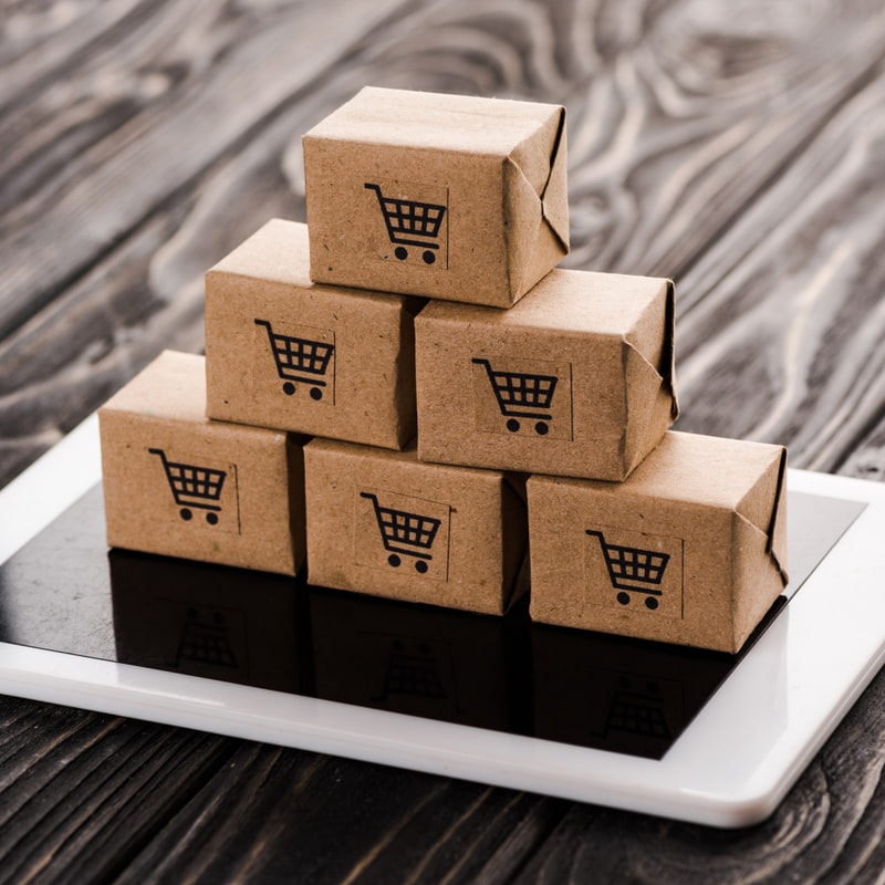 Small parcels marked with shopping carts stacked on a tablet